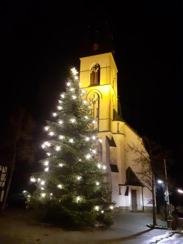 a christmas tree in front of a building with a clock tower at Ferienwohnungen Sternenhimmel WHG 1 in Medebach