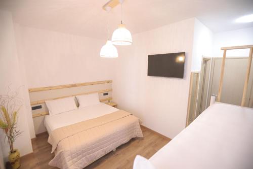 a bedroom with two beds and a flat screen tv at Nidum Harmony in Tirana