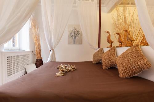 una camera da letto con un letto con lenzuola e cuscini marroni di Navona Historic Luxury Deluxe a Roma