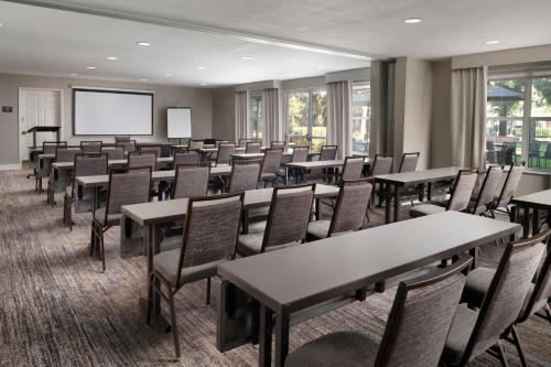 a conference room with tables and chairs and a screen at Residence Inn by Marriott Stockton in Stockton