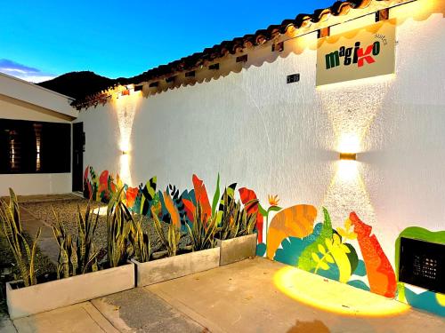 a white wall with a surfboard painted on it at Magiko Suites in Roldanillo