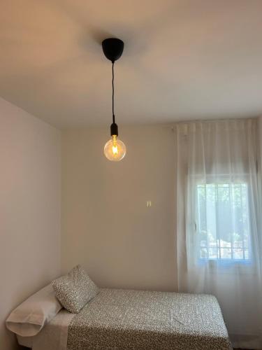 a bedroom with a bed and a light hanging from the ceiling at La Casita de Josefa in Zahara de la Sierra