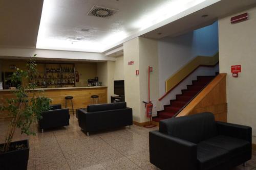 a lobby with a staircase and a bar with chairs at Hotel Europa in Palermo