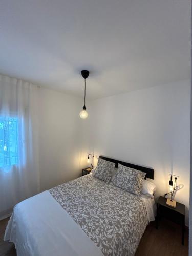 a bedroom with a white bed and a window at La Casita de Josefa in Zahara de la Sierra