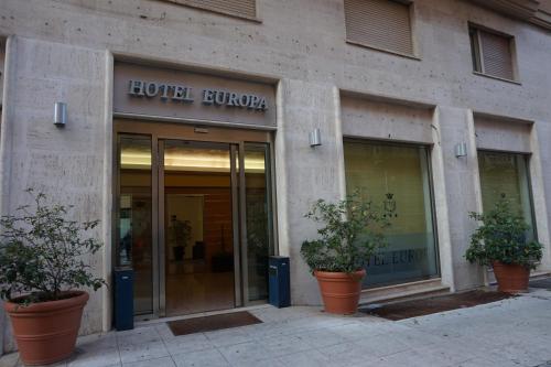 a hotel lobby with potted plants in front of a building at Hotel Europa in Palermo