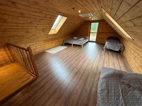a attic room with a bed and a couch at Ranczo Mokre in Łopuszno
