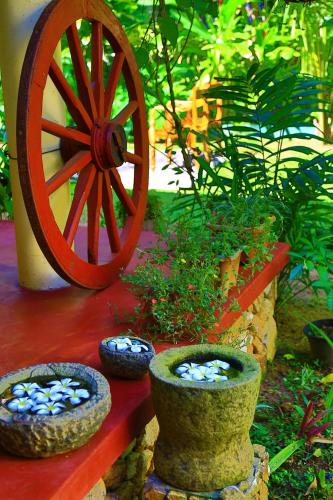 a wooden wagon wheel sitting next to some vases at Hotel Finlanka in Hikkaduwa