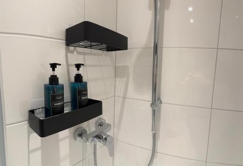 a bathroom with a shower with two bottles of soap at Boutique Apartment Loreley- charmante stillvolle Unterkunft in Osnabrück