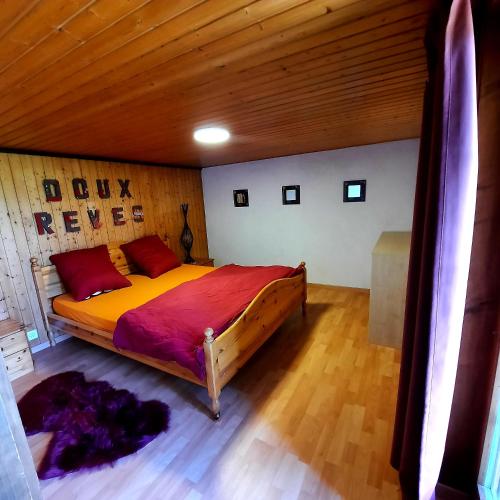 a bedroom with a large bed with a wooden ceiling at appartement de campagne seul in Ursy