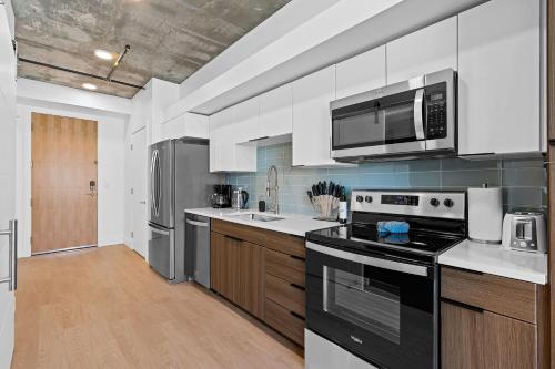 a kitchen with a stove and a microwave at Best views! Lux 9th fl Gym Pking Pool Htub King BD in Salt Lake City