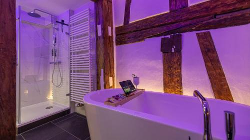 a bathroom with a bath tub with a laptop on it at Luxx Home RV, City Marienplatz in Ravensburg