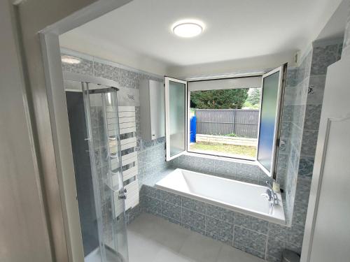 une salle de bain avec une baignoire et une fenêtre dans l'établissement *Gîte Aux Grappes du Pressoir* à 2 km de Beauval, à Seigy