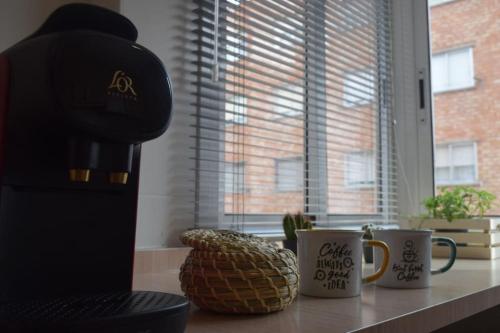 a coffee maker and two coffee cups on a counter at Inmejorable Apartamento cerca Estación Delicias con GARAJE in Zaragoza