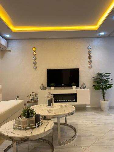 a living room with two tables and a flat screen tv at Mini Villa 2 Al hoceima in Al Hoceïma