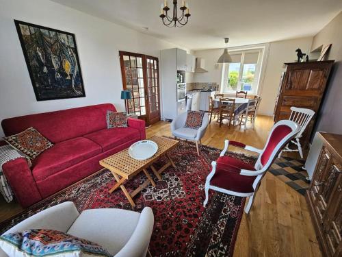 un salon avec un canapé rouge et une table dans l'établissement La Normandière - Maison de ville - Cosy - 6 pers, à Carantec