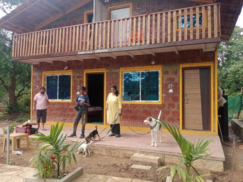 a group of people standing outside of a house with two dogs at Garden Villa Homestay ! Dandeli Ramnagar ! Eco Friendly Villa in Londa