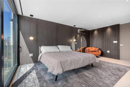 a bedroom with a large bed and an orange chair at 2 Story Villa in Upper Ditmars Astoria Queens in Steinway