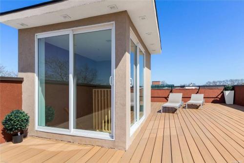 a patio with white chairs on a wooden deck at 2 Story Villa in Upper Ditmars Astoria Queens in Steinway