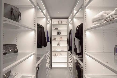 a walk in closet with white walls and white shelves at 2 Story Villa in Upper Ditmars Astoria Queens in Steinway