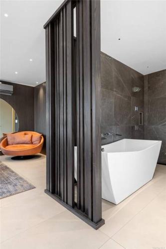 a bathroom with a white tub and a bath tub at 2 Story Villa in Upper Ditmars Astoria Queens in Steinway