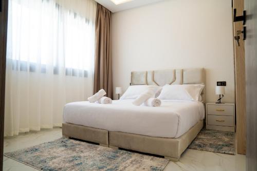 a bedroom with a large white bed and a window at Living Appart-Hotel in Tangier