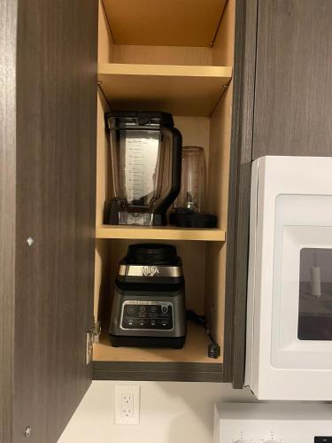 a coffeemaker is sitting inside of a cabinet at Modern, well-equipped, and centrally located in Fonthill