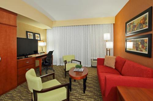 a hotel room with a red couch and a desk at Courtyard by Marriott St. George in St. George