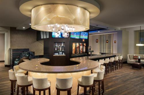 a bar with white chairs and a large chandelier at Courtyard by Marriott Irvine Spectrum in Irvine