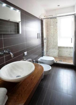 a bathroom with a white sink and a toilet at La Finestra Su Roma in Frascati
