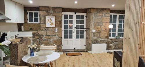a living room with a stone wall and a white door at Apartamentos Mirador de San Telmo in Tui