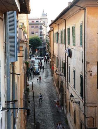 an alley with people walking down a street between buildings at La Finestra Su Roma in Frascati