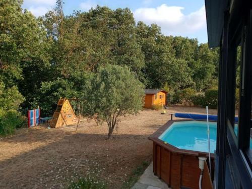 une cour avec une piscine et une aire de jeux dans l'établissement Maison de campagne avec piscine proche Carcassonne, à Raissac-sur-Lampy