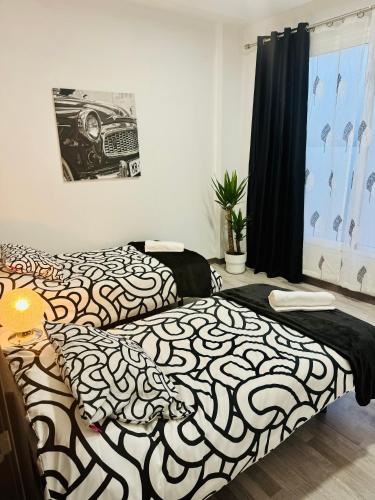 - une chambre avec 2 lits dotés de draps noirs et blancs dans l'établissement Duplex TH Sanse Norte, à San Sebastián de los Reyes