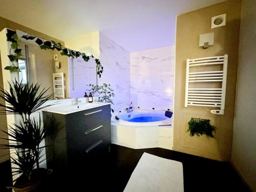 a bathroom with a tub and a sink at L'Élégant in Douvaine