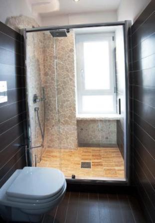 a bathroom with a shower with a toilet and a window at La Finestra Su Roma in Frascati