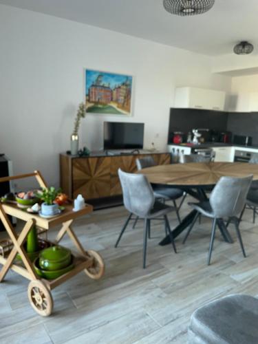 un salon avec une table et des chaises en bois dans l'établissement T3 cosy tout confort, à Collioure