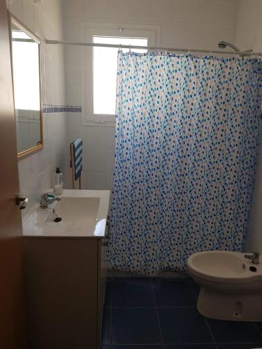 a bathroom with a toilet and a shower curtain at Lo Conseguí in Bollullos de la Mitación
