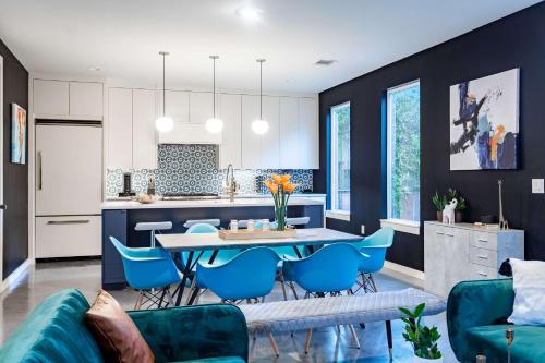 eine Küche und ein Wohnzimmer mit einem Tisch und blauen Stühlen in der Unterkunft Modern ATX Mansion 6th Street - 3 min scooter in Austin