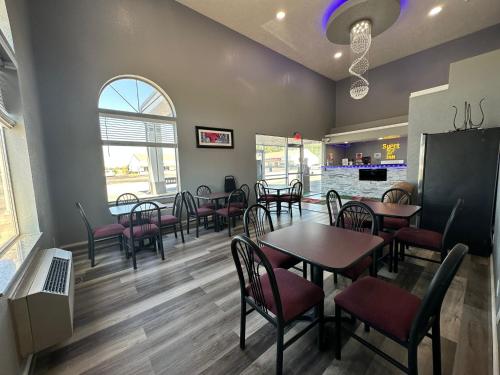 a dining room with tables and chairs in a restaurant at Super 7 Inn Tecumseh in Tecumseh