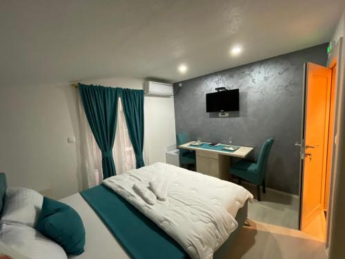 a small bedroom with a bed and a desk at Apartments Zejak in Mitrovići