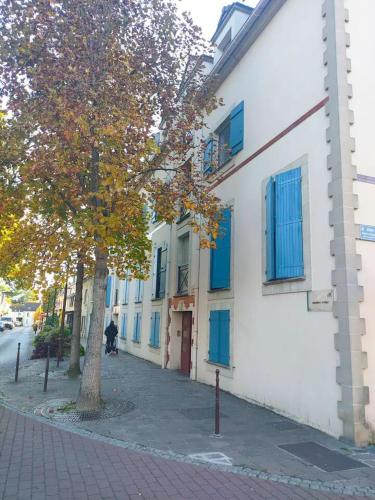 un arbre sur un trottoir à côté d'un bâtiment blanc dans l'établissement Charmant studio, à Roissy-en-France