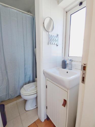 a bathroom with a toilet and a sink and a mirror at Cozy flat with marvelous view in Lisbon