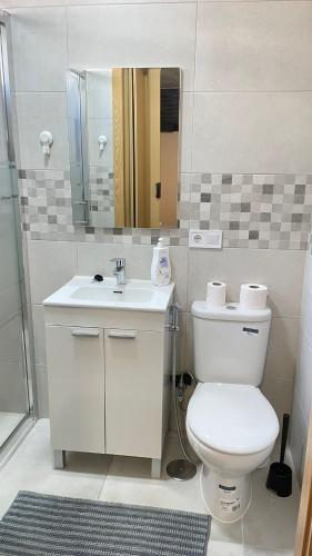 a bathroom with a toilet and a sink and a mirror at Luxury Estudio CH&H in Benalmádena