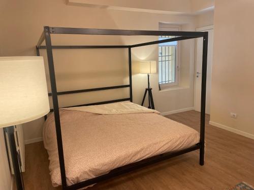 a bedroom with a bed with a black frame at Appartamento del vicolo in Brescia