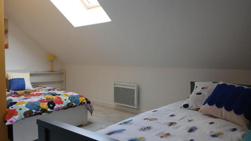 a bedroom with two beds and a window at Au bout du Mont in Pontorson