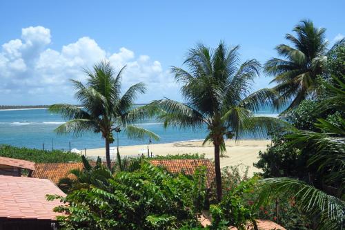 a view of a beach with palm trees and the ocean at Pousada Nascente do Sol in Ilha de Boipeba