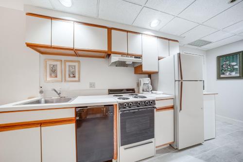 a kitchen with white cabinets and a sink and a refrigerator at Experience Chautauqua! Newly Renovated Studio in Chautauqua