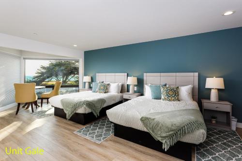 a bedroom with two beds and a blue wall at Windrush Inn - Cambria in Cambria