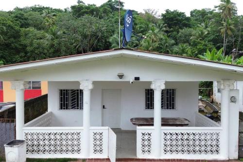 a white house with a flag on top of it at Casa de Playa la Perfecta a 10 metros de la playa in Colón