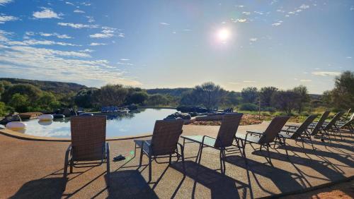 a group of chairs sitting in front of a pool at Ooraminna Homestead in Alice Springs
